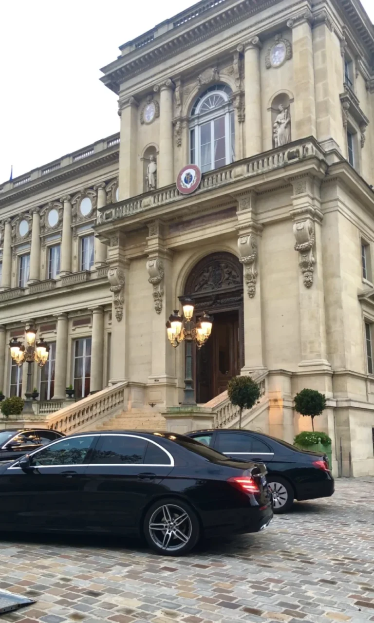 Black Mercedes saloons parked in a cobbled palace courtyard.